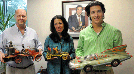 Auction house principal Jeanne Bertoia, center, with the Bing touring car that sold at $59,800; her brother-in-law Rich Bertoia, left, with the Marklin fire-pumper, $149,500; and her son Michael with the Atomic Racer that sold for $21,850.