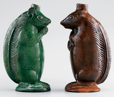 A squirrel bottle face-off: the green bottle on the left chews on a nut, the one on the right watches and waits.