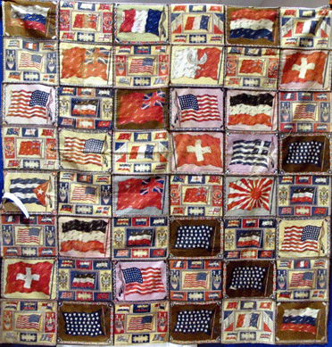 An early Twentieth Century coverlet with flags of the world made of tobacco silks hangs at Certain Books LLC, Westhampton, N.Y. 