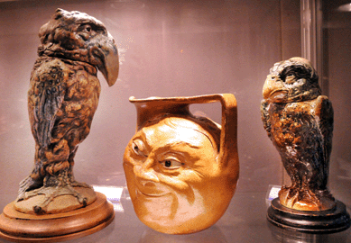 A selection of Martin Brothers pottery displayed by Philip Carrol, Yorkshire, UK. The bird on the left, in an unusual biscuit finish, was $57,000, the face jug $17,850, and the smaller bird figure with restoration was $28,500.