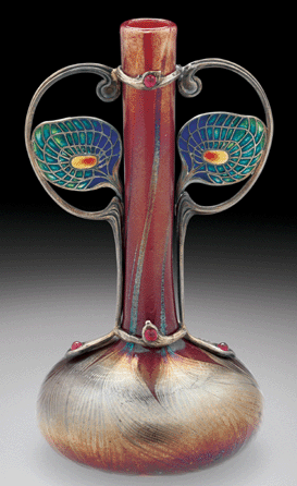 The striking Tiffany blown glass peacock feather vase was made in 1899 with silver gilt, plique-a-jour enamel and rubies. The silver mounting is by Edouard Colonna, the enamelling by Eugene Feuillatre.