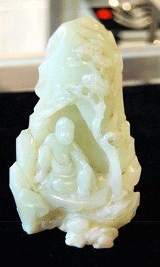 A Qing dynasty carved quartz figure with a carved and pierced green jade screen that was decorated with polished red stones sold for $13,800.