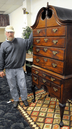 Auctioneer Joe Kabe with the estate-fresh Goddard Townsend bonnet top highboy, one of 12 known, that sold for $431,250.