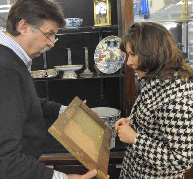 Auctioneer Russ Carlsen, left, shows a painting to Evelyn Trebilcock, the curator at Olana, the Frederic Edwin Church homestead on the Hudson River.