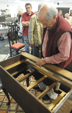 Ohio dealer Bill Samaha looks over the Goddard Townsend highboy during preview. Samaha later purchased the lot for $431,250.