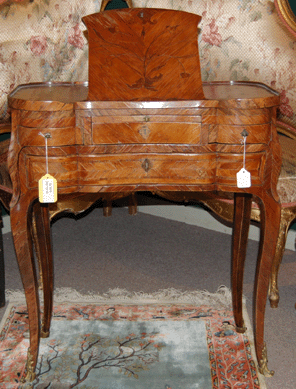 A dainty Louis XV tulipwood and kingwood table d'accouchee with marquetry inlay, and made with a reading and writing stand, a vanity mirror, wells and drawers, sold for $17,250.