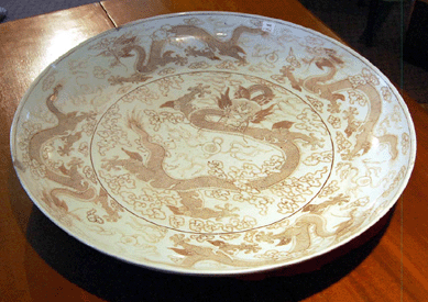 A 25¼-inch Chinese porcelain charger, circa 1750, with underglaze red decoration of a five-clawed dragon in pursuit of the pearl attracted vigorous bidding and sold for $42,480.