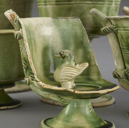Green-splashed stem cup. Concealing the entrance to its built-in drinking spout, this sipping cup is not only charming, but also represents one of many exciting shapes produced in Ninth Century ceramic production. With its distinctive green-splashed glaze, the cup fits into a rare group of items comprising the cargo's most distinctive forms. Smithsonian's Freer and Sackler Galleries. 