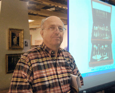 Auctioneer Charlie Cobb takes a breath before he hoists the gavel. The Gorham sterling flatware service for eight in the 1816 pattern shown on the screen behind him realized $1,840.