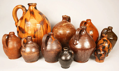 A group of Tennessee jugs attributed to the Cain Pottery in Sullivan County. Noteworthy are the extruded handles, the fingerprint at the base of the handles, sine wave decorations and footed bases.