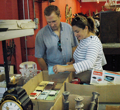 Gallery patrons check out a box lot of vintage model cars during preview.