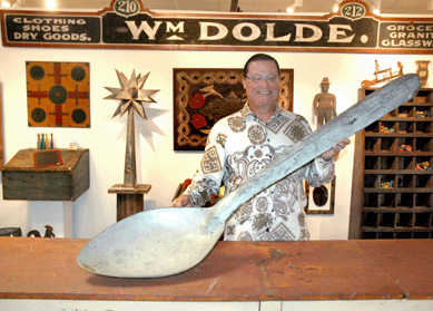 Tim Chambers of Missouri Plain Folk shows off a spoon that looks small compared to his 16-foot, 8-inch-long table.