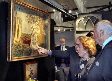Mo Wajselfish, center, of Leatherwood Antiques, Sandwich, Mass., shows clients "The Finding of Moses,†an English naïve appliquéd and embroidered picture of circa 1815.