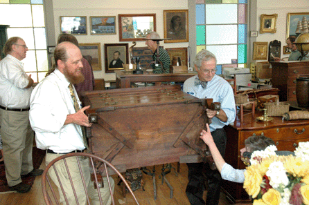 Arthur Liverant, right, and Kevin Tulimieri, turn a piece of furniture for one of the visitors to the open house.