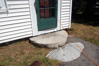 One of several millstones on the property sold for $1,955. Auctioneer McInnis volunteered to help watch representatives from the successful bidder, the Historical Society of Old Newbury, move it.