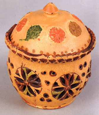 This rare Pennsylvania redware covered sugar bowl, circa 1840, attributed to Henry Grady, Somerset County, the lid with eight molded stars and dotted edge, resting on a base with sawtooth rim and body with reticulated pinwheels, 5½ inches high, carried an estimate of $10/15,000 and sold to a Pennsylvania collector for $59, 250.