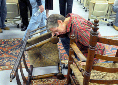 Looking over the early American ladder back great chairs during preview.