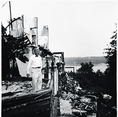 Hugh McKean is pictured inspecting the ruins of Laurelton Hall after the 1957 fire.
