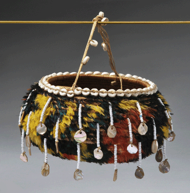 The most gaily decorated piece in the exhibition, a Pomo feathered basket with a string handle, was created in Northern California, 1900‱930, for sale to tourists. It is made of sedge root coiled on a one-rod willow foundation, woodpecker feathers and clamshell and glass beads. ⁓usan Einstein photo