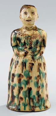 An unusual bottle in the form of a lady with overall white slip highlighted by copper and manganese drippings. Salem, N.C., circa 1806‱830, height 7¼ inches.