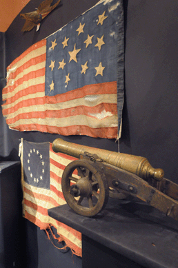 The 13-star American flag, top, sold at $17,250, the 13-star flag made $373, and the Nineteenth Century turned brass cannon brought $2,300.
