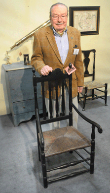 Salisbury, Conn., dealer Don Buckley with one of the numerous banister back great chairs from his stand.