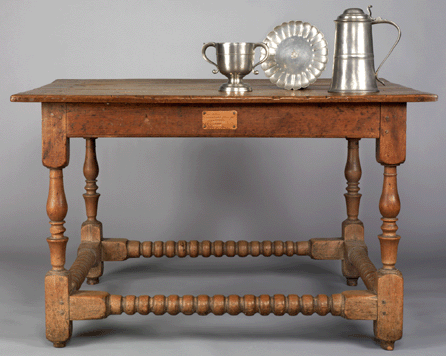 The walnut communion table was made for the 1740 Donegal Presbyterian Church, Mount Joy, Penn., and is thought to have been made by a local Lancaster County craftsman. The pewter communion service is part of a larger set. The two-handled cup and flagon were made by William Eddon of London, circa 1720‱735, and the paten is by Richard King, also of London.