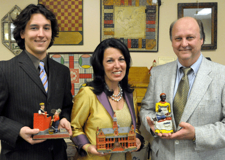 The Bertoia Auctions clan, second generation toy expert Michael Bertoia with the Mason bank that sold for $46,000, auction house principal Jeanne Bertoia with the Ives Palace still bank that brought $23,000, and Jeanne's brother-in-law and bank expert Rich Bertoia with the Mammy and Child bank that realized $51,750.