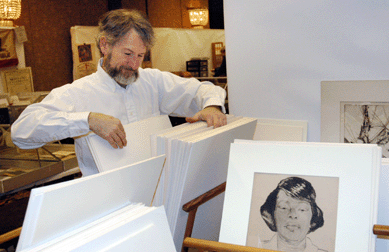 Marc Chabot Fine Arts, Southbury, Conn., reviews his inventory of works of art on paper before the show opens.