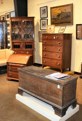 A sampling of North Carolina decorative arts included this painted blanket chest of yellow pine with six-board construction, step-cut bracket feet and combed decoration, $748. Right rear is a Piedmont Federal walnut semi-tall chest of drawers, $5,060. Above, "Sunset at Blowing Rock,†a Blue Ridge mountain scene, $13,800, by North Carolina artist Elliott Daingerfield (1858‱932). The Federal secretary bookcase, left, fetched $1,840.