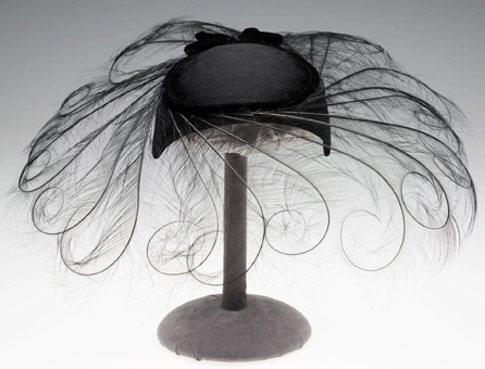 In the 1950s and 1960s, carefully chosen and coordinated accessories were essential to transforming a simple dress into a winning ensemble. A whimsical, feather-trimmed cartwheel hat, such as this one by Joseph's New York, along with sparking jewelry and perhaps gloves, epitomized the ladylike, "smart†style of the era. Gift of Albert E. Simonson.