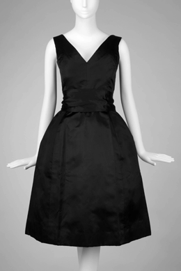 Christian Dior, credited with coining the phrase "cocktail dress,†designed this example in 1954. Its heavyweight black satin accented yet concealed the figure, its demure V-neck could frame a necklace and its full skirt underscored its femininity, all in all, adding glamour to a woman's transition from sundown to night. Gift of Ronald and Lillian Dick.