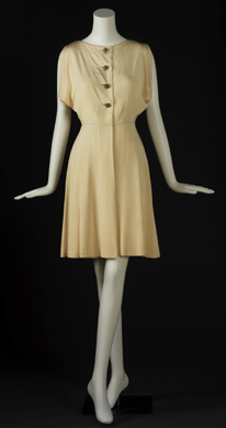 Keeping up with changing tastes and times, Norman Norell continued to provide women with elegant frocks into the 1970s era of the jet set. His cream silk dress, replete with rhinestones and gold buttons, qualified as a couture garment. Gift of Mrs Milton Cassel.
