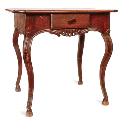 A colonial walnut pied de biche table, so-named for its cloven hoof feet, adheres closely to French provincial traditions. Its skirt is decorated on all sides, allowing it to be used against the wall or in the middle of a room. The Sebastian Louis Kleinpeter Home.