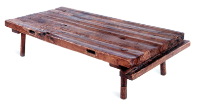 A vernacular cypress boucherie table was used in Acadian households to prepare and preserve meats. The grooved surface allows fluids to flow into the collecting gutter at the end. Bernard family collection.