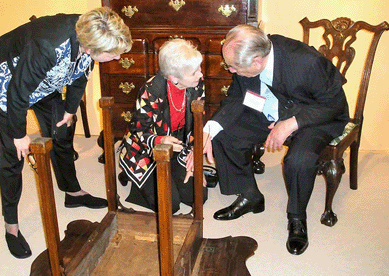 Sack conferring with Milly McGehee and Deanne Levison, right, on the finer points of this Pembroke table.
