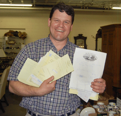 Auctioneer Douglas W. Stinson is pictured with just a few of the original receipts for objects gathered by Robert J. Morris, who kept meticulous records of his collections.