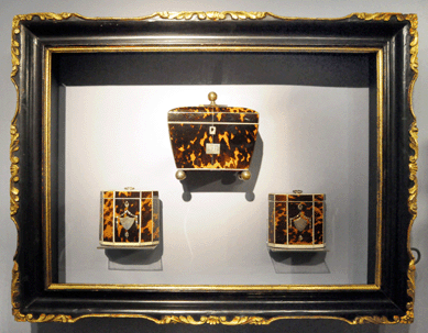 A nicely framed group of tortoiseshell tea caddies in the stand of Sallea Antiques, New Canaan, Conn.