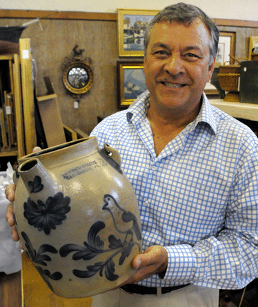 Auctioneer Rafael Osona with the rare 2-gallon batter jug by Cowden and Wilcox. Osona's asked for a $10,000 opening bid for the jug †and got it immediately from the bidder who eventually won the lot at  $29,000.