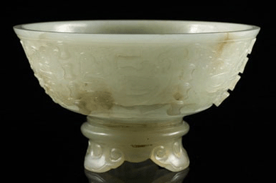 An Eighteenth Century Chinese jade bowl carved with archaic designs on a separate jade stand that raised $35,650.