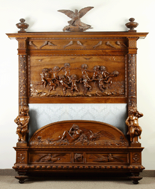 A monumental Victorian carved walnut bed by Luigi Frullini featured frolicking cherubs, birds, owls, bats, reclining nude, poppies, climbing ivy, flowers and stars. It sold on the floor for $28,750.