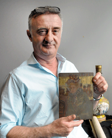 Auctioneer Ronan Clarke with the Maurice Prendergast oil on panel that had been discovered in a box lot. It sold to a private buyer for $164,500.