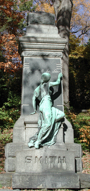 Affixed to the Smith headstone in the cemetery, this bronze statue was done by an unknown artist in the Romantic style, depicting a woman turning her back on the world, writing on the stone of the life to come. Daniel M. Lynch photo