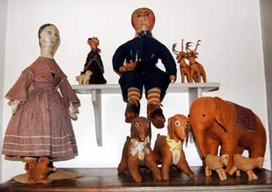 Elephants are a Cook favorite. A choice example marches with several rare pairs: dogs, birds, reindeer and cows in a vignette with early dolls whose faces may have been drawn after they were made.