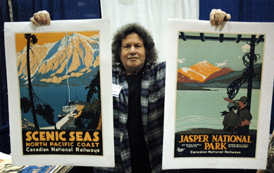 Morris Steinbock of Nancy Steinbock Posters, Chestnut Hill, Mass., holds a couple of examples of rare scenic posters that were garnering much attention at the show.