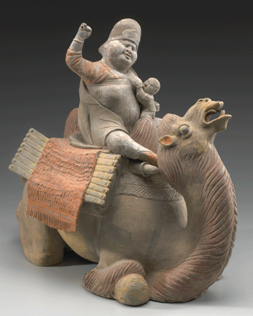 This tomb figure depicts a Turkic caravan woman rousing her camel while nursing. It is earthenware with unfired coloring and from the Tang dynasty. Purchase: the Richard J. Stern Foundation for the Arts †Commerce Bank, Trustee and Hall Family Foundation Endowment for the Oriental Department.