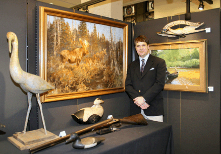 Copley Fine Arts Chairman Stephen O'Brien Jr with the sale's top lot, left, "In the Cedar Swamp,†$241,500, an oil on canvas by Carl Rungius. Right is Bob F. Kuhn's 1974 acrylic on board "A Two Brooks Idyll,†$17,350. From left, a circa 1920 Sandhill crane by Gus Wilson, South Portland, Maine, $4,600; swimming bluebill drake by John Blair Jr, Philadelphia, circa 1920, with John Blair Sr's Belgian shotgun, $13,800; eider drake by Amos G. Wallace, West Point, Maine, circa 1910, passed at $6/8,000; and a carved eagle plaque by John Haley Bellamy, Kittery, Maine, circa 1890, sold within estimate at $21,850.