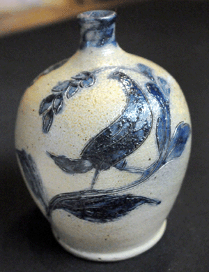 The Cowden and Wilcox batter jug, decorated with a floral sprig on the front, a bird on each side and a pair of birds above the lug handle on the rear, sold for $31,050.
