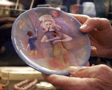 Buxton, Maine, dealer Bob Brandow of Laurel Antiques of Maine holds up a plate decorated by Polia Pillin.