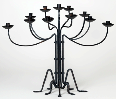 The 11-light, wrought iron candelabrum has feet that resemble spider legs. The piece is large but graceful, measuring 28½ by 35¼ by 17½ inches. 